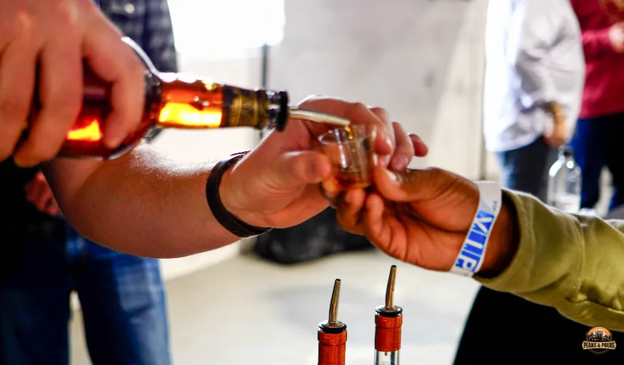 Whiskey being poured at a tasting station at Peaks and Pours 2023