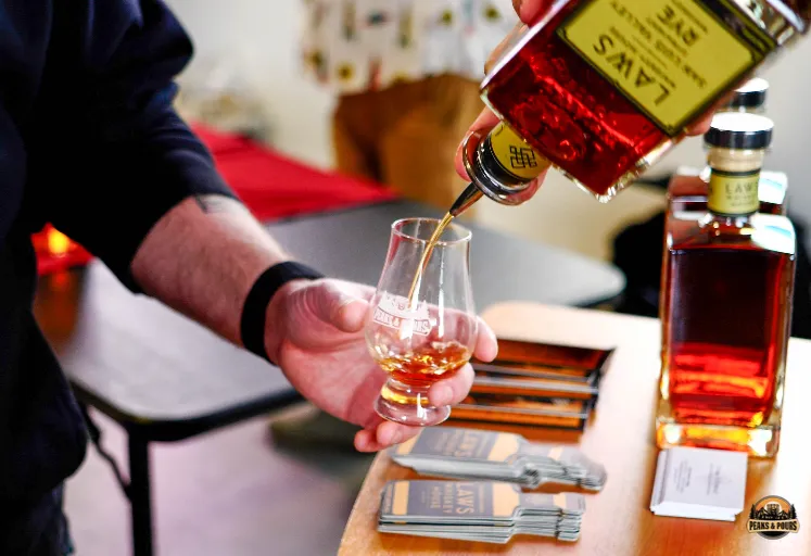 Attendee receiving a pour of Law's Rye at Peaks and Pours 2023