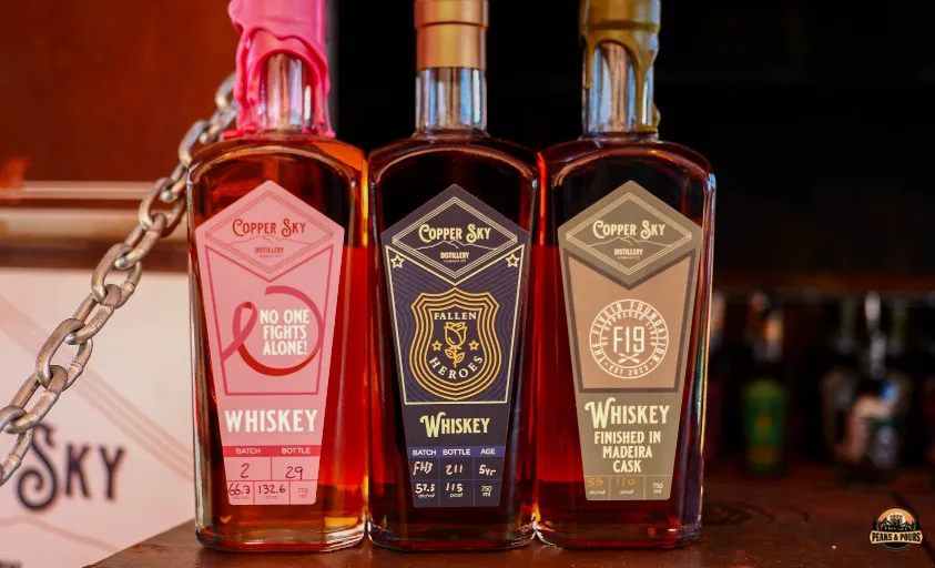 Copper Sky Distillery whiskey bottles including No One Fights Alone, Fallen Heroes, and F19 Madeira Cask at Peaks and Pours 2023
